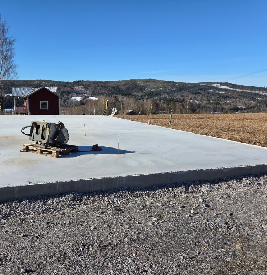 Nylagd betongplatta med utsikt över bergen, förberedd för garagebygget.
